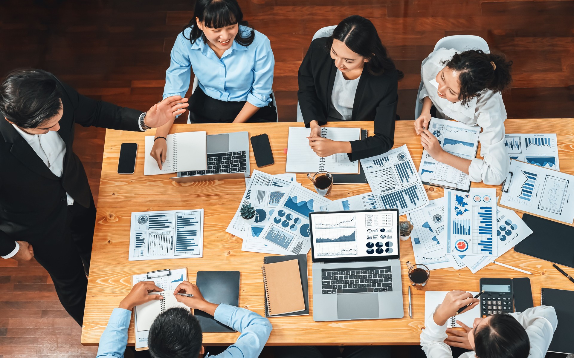 Wide top view diverse analyst team analyzing financial data. Habiliment